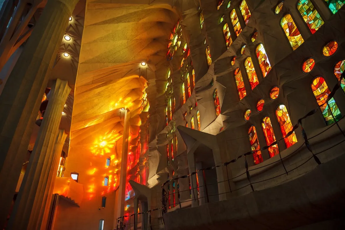 Lumière des vitraux de la Sagrada Familia projetée sur les visiteurs à l'intérieur de la basilique