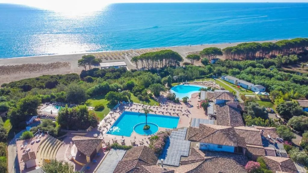 Vista aérea del Perdepera Resort con piscinas y playa, Cerdeña