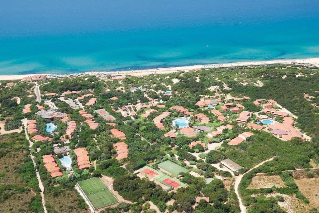 Vista del Resort & SPA Le Dune con palmeras en Badesi, Cerdeña